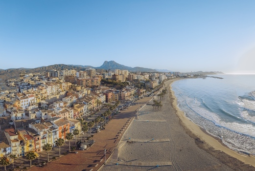 Aerial view of colorful houses along the promenade sandy beach and Mediterranean coastline with mountains in the background La Vila Joiosa Valencian Community Spain. Aerial view of colorful houses along the promenade sandy beach and Mediterranean coastline with mountains in the background La Vila Joiosa Valencian Community Spain.
