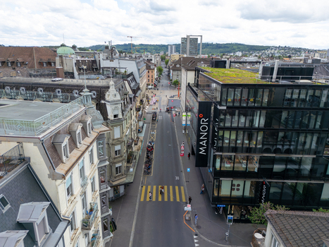 Aerial view of the urban landscape featuring historic architecture and modern glass buildings along a central street under a cloudy sky in Biel Bienne Canton of Bern Switzerland. Aerial view of the urban landscape featuring historic architecture and modern glass buildings along a central street under a cloudy sky in Biel Bienne Canton of Bern Switzerland.