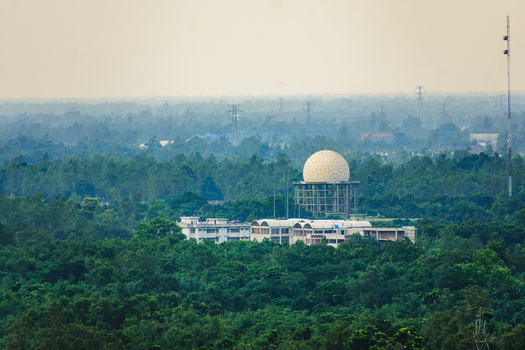 Aerial view of a radar dome structure surrounded by lush green forest and low rise buildings in Bogura Rajshahi Division Bangladesh. Aerial view of a radar dome structure surrounded by lush green forest and low rise buildings in Bogura Rajshahi Division Bangladesh.