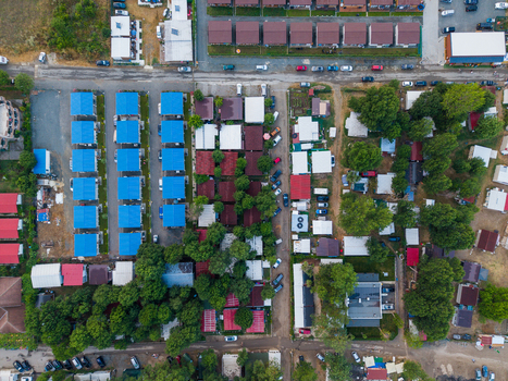 Aerial view of Arapya campsite featuring rows of small cabins with blue roofs lush green trees and parked cars in a coastal resort area Burgas Bulgaria. Aerial view of Arapya campsite featuring rows of small cabins with blue roofs lush green trees and parked cars in a coastal resort area Burgas Bulgaria.