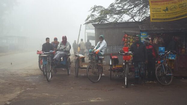 View of rickshaw pullers on a foggy street in Bogura Bangladesh. View of rickshaw pullers on a foggy street in Bogura Bangladesh.