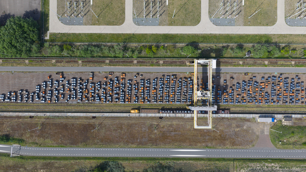Aerial view of Tata Steel plant featuring rows of steel coils in a storage yard with a gantry crane and electrical infrastructure in Velsen Noord Noord Holland Netherlands. Aerial view of Tata Steel plant featuring rows of steel coils in a storage yard with a gantry crane and electrical infrastructure in Velsen Noord Noord Holland Netherlands.