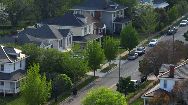 Aerial view of a quiet residential street lined with historic houses lush green trees and parked cars in Lynchburg Virginia United States.