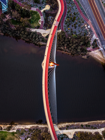 Aerial view of Boorloo Bridge spanning the Swan River with its red path and cable stayed structure surrounded by parklands in East Perth Western Australia Australia.