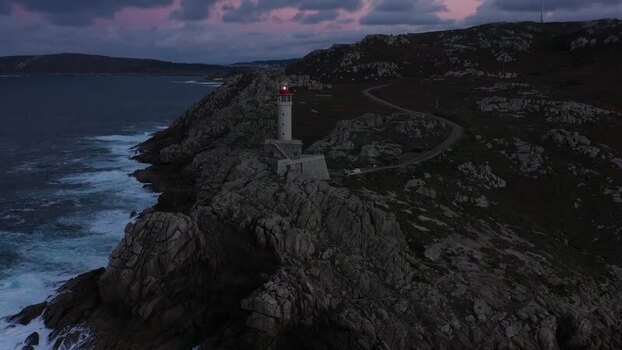 Aerial view of Faro de Punta Nariga on rocky cliffs Spain.