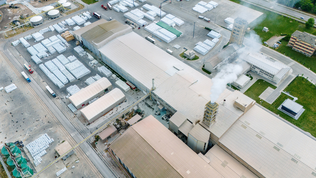 Aerial view of a large industrial facility with warehouses smoking chimneys and stacked cargo pallets in Sabac Vojvodina Serbia. Aerial view of a large industrial facility with warehouses smoking chimneys and stacked cargo pallets in Sabac Vojvodina Serbia.