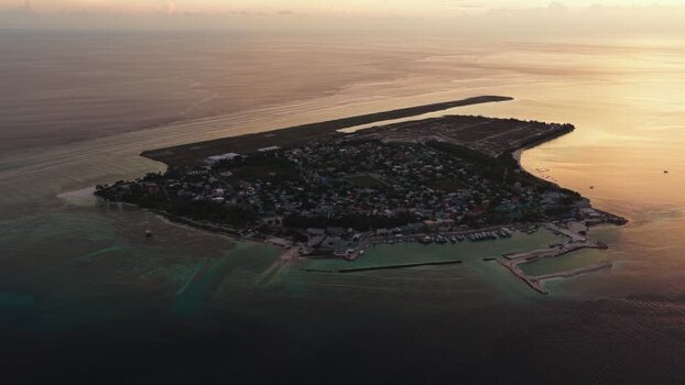 Aerial view of Kudahuvadhoo island and airport at sunset Maldives.