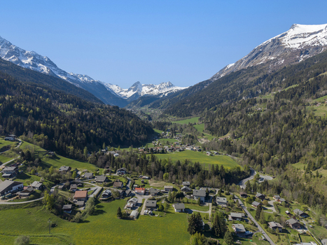 Saint Gervais les Bains France 30 April 2026 Aerial view of Saint Gervais les Bains village nestled in a lush green valley surrounded by the snow capped peaks of the French Alps under a clear blue sky.