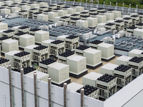 Aerial view of a data center rooftop featuring rows of industrial cooling units and ventilation fans in the United Kingdom.