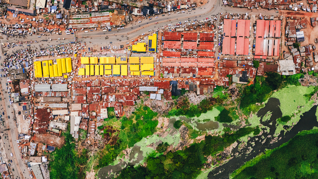 Aerial view of vibrant market stalls bursting with color against the backdrop of buildings and green vegetation Abeokuta Ogun State Nigeria.