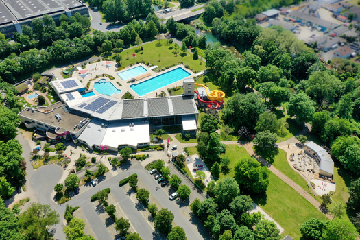 Aerial view of Konigsbad Forchheim featuring outdoor swimming pools colorful water slides and sunbathing lawns surrounded by lush trees Forchheim Bayern Germany. Aerial view of Konigsbad Forchheim featuring outdoor swimming pools colorful water slides and sunbathing lawns surrounded by lush trees Forchheim Bayern Germany.