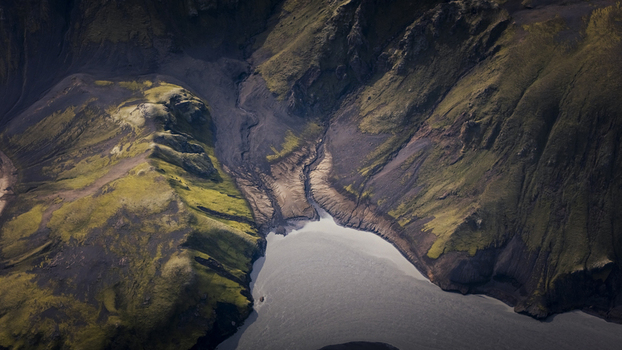 Aerial view of Langisjor lake surrounded by rugged volcanic mountains moss covered slopes and dark basaltic terrain in Vik Skaftarhreppur Iceland. Aerial view of Langisjor lake surrounded by rugged volcanic mountains moss covered slopes and dark basaltic terrain in Vik Skaftarhreppur Iceland.