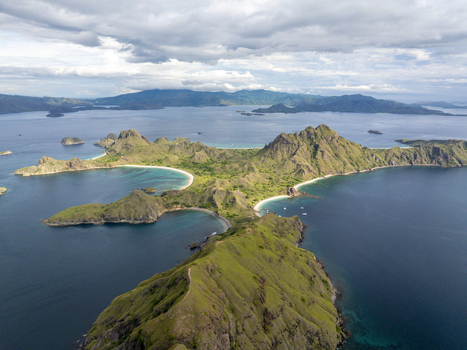 Aerial view of Padar Island with its iconic crescent shaped beaches dramatic green hills and turquoise waters in Komodo East Nusa Tenggara Indonesia. Aerial view of Padar Island with its iconic crescent shaped beaches dramatic green hills and turquoise waters in Komodo East Nusa Tenggara Indonesia.