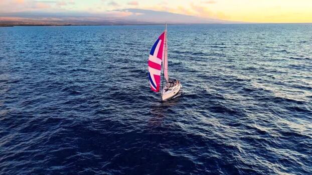Aerial view of a sailboat with a colorful sail United States. Aerial view of a sailboat with a colorful sail United States.