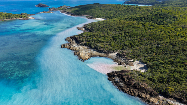Aerial view of Chance Bay with its turquoise waters rocky coastline and lush green vegetation in the Whitsundays Queensland Australia. Aerial view of Chance Bay with its turquoise waters rocky coastline and lush green vegetation in the Whitsundays Queensland Australia.
