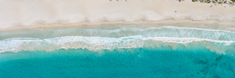 Aerial view of the pristine coastline with turquoise ocean waves gently breaking on the white sandy beach in Perth Western Australia Australia. Aerial view of the pristine coastline with turquoise ocean waves gently breaking on the white sandy beach in Perth Western Australia Australia.