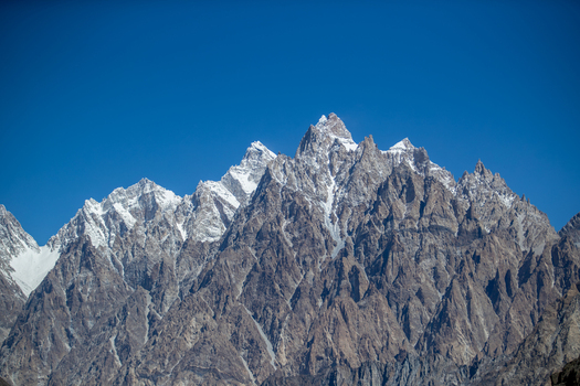 View of the jagged peaks of the Passu Cones also known as Cathedral Ridge rising against a clear blue sky in the Karakoram mountain range in Passu Gilgit Pakistan. View of the jagged peaks of the Passu Cones also known as Cathedral Ridge rising against a clear blue sky in the Karakoram mountain range in Passu Gilgit Pakistan.