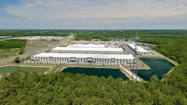 Aerial view of large industrial warehouses near Saint Johns Parkway surrounded by dense green forests and retention ponds in World Golf Village Florida United States. Aerial view of large industrial warehouses near Saint Johns Parkway surrounded by dense green forests and retention ponds in World Golf Village Florida United States.