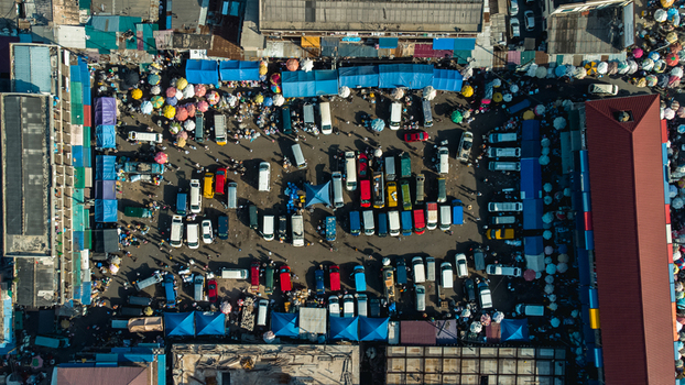 Accra Ghana 26 May 2023 Aerial view of a bustling outdoor market with numerous parked vehicles colorful stalls and crowds of people navigating the busy urban space. Accra Ghana 26 May 2023 Aerial view of a bustling outdoor market with numerous parked vehicles colorful stalls and crowds of people navigating the busy urban space.