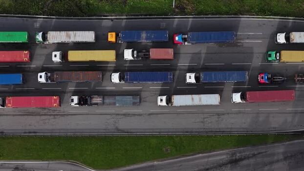 Aerial view of cargo trucks on the road with shipping containers Portugal.