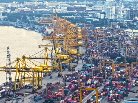 Aerial view of the busy Chattogram Port featuring numerous yellow gantry cranes and rows of colorful shipping containers along the waterfront in Chittagong Chittagong Division Bangladesh.