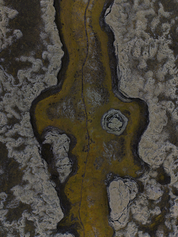 Aerial view of a narrow winding river cutting through a textured landscape of contrasting light and dark tones shapes and forms Lakagigar Iceland. Aerial view of a narrow winding river cutting through a textured landscape of contrasting light and dark tones shapes and forms Lakagigar Iceland.