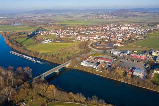 Aerial view of the Liapor GmbH and Co. KG industrial facility and a cargo barge navigating the river near the town of Hallerndorf Bayern Germany. Aerial view of the Liapor GmbH and Co. KG industrial facility and a cargo barge navigating the river near the town of Hallerndorf Bayern Germany.