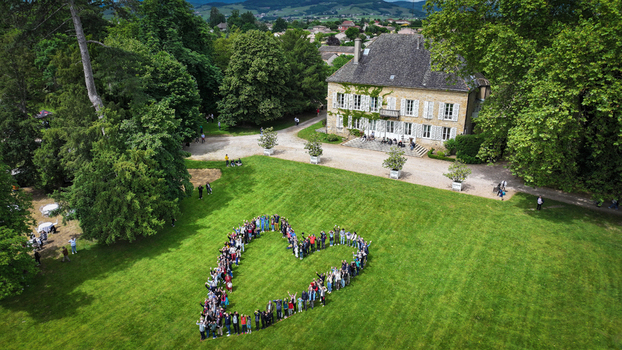 La Chapelle de Guinchay France 01 June 2024 Aerial view of a large group of people forming a heart shape on a green lawn in front of a historic manor house surrounded by lush trees. La Chapelle de Guinchay France 01 June 2024 Aerial view of a large group of people forming a heart shape on a green lawn in front of a historic manor house surrounded by lush trees.