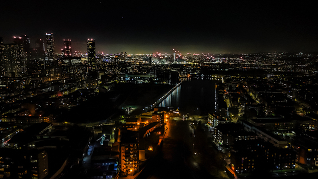 Aerial view of the illuminated London skyline at night featuring skyscrapers urban lights and the dark waters of the Thames London England United Kingdom. Aerial view of the illuminated London skyline at night featuring skyscrapers urban lights and the dark waters of the Thames London England United Kingdom.