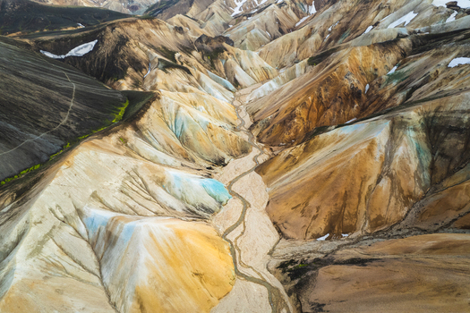 Aerial view of Landmannalaugar rhyolite mountains with colorful slopes and a winding riverbed in the highlands Rangarthing ytra Iceland. Aerial view of Landmannalaugar rhyolite mountains with colorful slopes and a winding riverbed in the highlands Rangarthing ytra Iceland.
