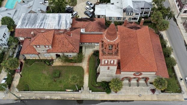 Aerial view of Grace United Methodist Church featuring its distinctive terracotta roof and bell tower surrounded by lush green lawns and palm trees in St. Augustine Florida United States. Aerial view of Grace United Methodist Church featuring its distinctive terracotta roof and bell tower surrounded by lush green lawns and palm trees in St. Augustine Florida United States.