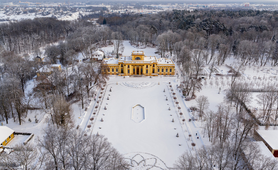 Aerial view of the yellow Traku Voke Manor surrounded by snow covered trees and a large frozen courtyard in winter Vilnius Vilniaus apskritis Lithuania.