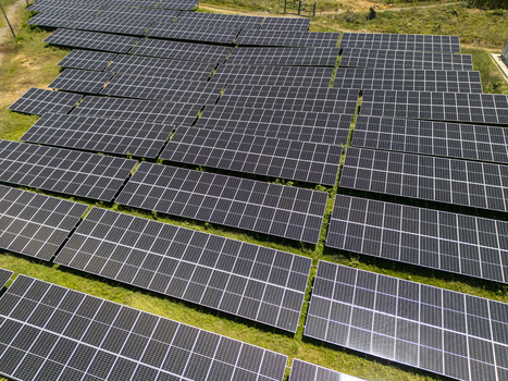Aerial view of the Guanaja solar farm with rows of photovoltaic panels on a grassy field Guanaja Bay Islands Department Honduras.
