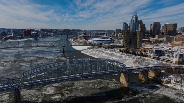 Aerial view of the Cincinnati skyline and the Ohio River filled with ice floes near snow covered banks and steel bridges in Cincinnati Ohio United States. Aerial view of the Cincinnati skyline and the Ohio River filled with ice floes near snow covered banks and steel bridges in Cincinnati Ohio United States.