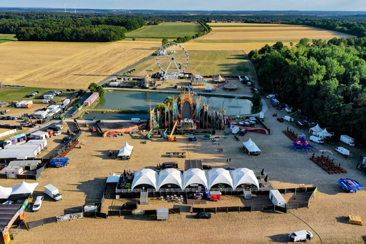 Herzogenaurach Germany 22 July 2022 Aerial view of the Open Beatz Festival grounds featuring a large ferris wheel main stage and white tents surrounded by agricultural fields. Herzogenaurach Germany 22 July 2022 Aerial view of the Open Beatz Festival grounds featuring a large ferris wheel main stage and white tents surrounded by agricultural fields.