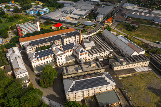 Aerial view of the Hodonin Power Station featuring industrial buildings with solar panels on rooftops under bright daylight in Hodonin Jihomoravsky kraj Czechia. Aerial view of the Hodonin Power Station featuring industrial buildings with solar panels on rooftops under bright daylight in Hodonin Jihomoravsky kraj Czechia.