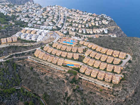 Aerial view of residential complexes with swimming pools situated on the cliffs overlooking the Mediterranean Sea in Moraira Valencian Community Spain.