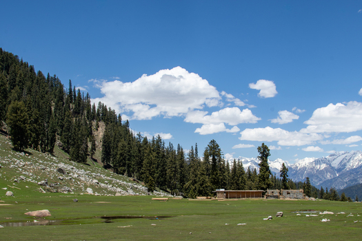 View of Jahaz Banda Alpine Rest House nestled in a lush alpine meadow surrounded by pine forests and snow capped mountains in Kumrat Valley Khyber Pakhtunkhwa Pakistan. View of Jahaz Banda Alpine Rest House nestled in a lush alpine meadow surrounded by pine forests and snow capped mountains in Kumrat Valley Khyber Pakhtunkhwa Pakistan.