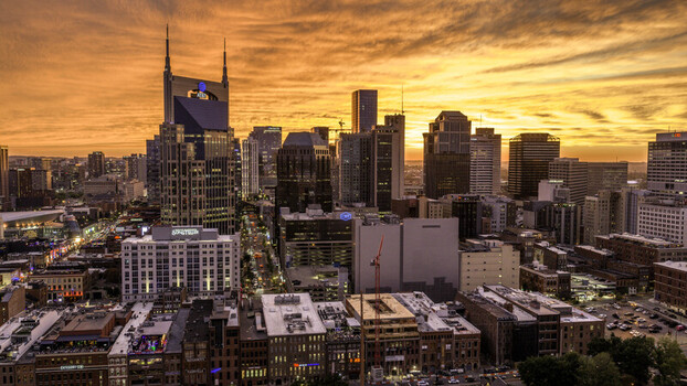 Aerial view of the Nashville skyline at sunset with the ATT Building historic brick buildings and glowing city lights in Nashville TN United States.