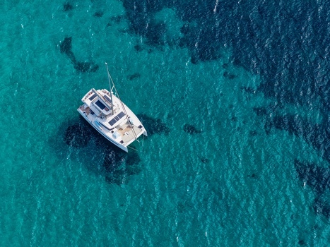 Aerial view of a white catamaran anchored in the clear turquoise waters near Ile Sainte Marguerite in Cannes Provence Alpes Cote d Azur France. Aerial view of a white catamaran anchored in the clear turquoise waters near Ile Sainte Marguerite in Cannes Provence Alpes Cote d Azur France.