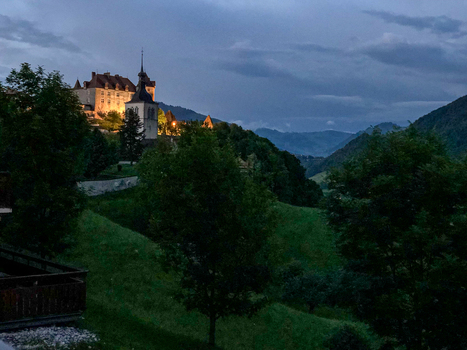 Gruyeres Switzerland 14 May 2026 View of the illuminated Gruyeres Castle perched on a hill at dusk surrounded by lush green slopes and forests under a cloudy evening sky. Gruyeres Switzerland 14 May 2026 View of the illuminated Gruyeres Castle perched on a hill at dusk surrounded by lush green slopes and forests under a cloudy evening sky.
