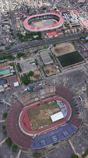 Aerial view of the National Stadium Surulere Lagos and surrounding sports facilities amidst the dense urban landscape and busy roads of Lagos Lagos Nigeria.