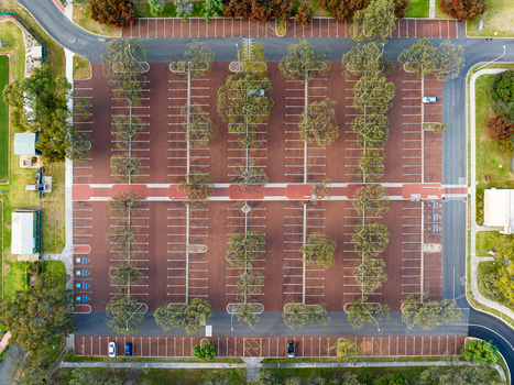 Aerial view of Percy Doyle Reserve parking lot featuring rows of parking spaces shaded by trees and red toned pavement in Duncraig Western Australia Australia. Aerial view of Percy Doyle Reserve parking lot featuring rows of parking spaces shaded by trees and red toned pavement in Duncraig Western Australia Australia.