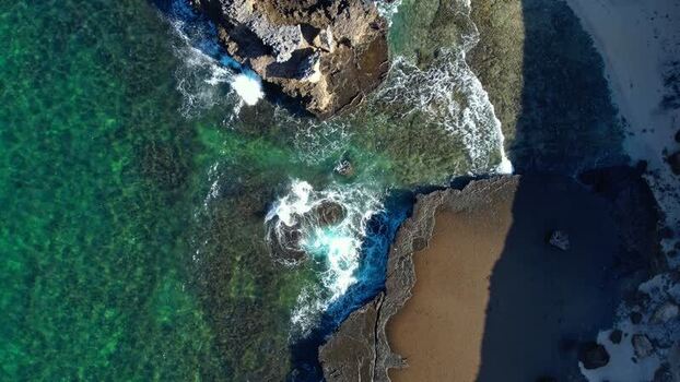 Aerial view of waves crashing on the rocky coast of Indonesia. Aerial view of waves crashing on the rocky coast of Indonesia.