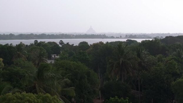 Aerial view of a distant stupa across the water in Sri Lanka.