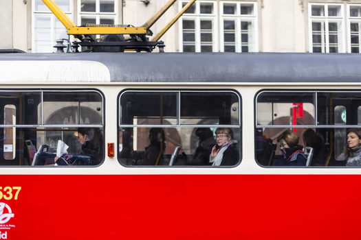 Prague Czechia 25 November 2022 View of passengers sitting inside a red and white tram passing through the historic streets of Prague.