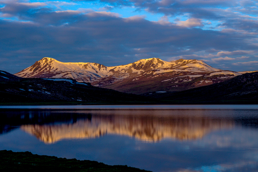 View of Sheosar Lake with snow capped mountains reflecting in the calm water under a dramatic sunset sky in Skardu Pakistan. View of Sheosar Lake with snow capped mountains reflecting in the calm water under a dramatic sunset sky in Skardu Pakistan.