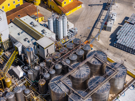 Aerial view of an industrial facility featuring numerous stainless steel storage tanks complex piping systems and yellow buildings Spoleto Umbria Italy. Aerial view of an industrial facility featuring numerous stainless steel storage tanks complex piping systems and yellow buildings Spoleto Umbria Italy.