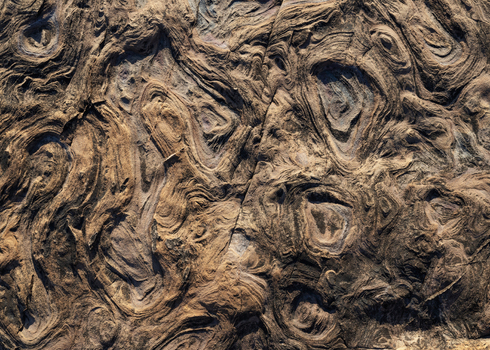 View of eroded rock formations with unique circular patterns and swirling textures at Calafuria Toscana Italy.