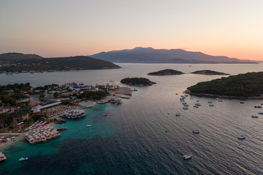 Aerial view of the coastal town with turquoise water small islands and beach resorts at sunset in Ksamil Vlore County Albania. Aerial view of the coastal town with turquoise water small islands and beach resorts at sunset in Ksamil Vlore County Albania.